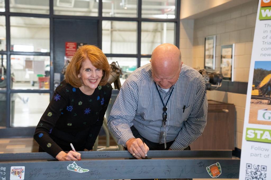 Beth Pitonzo and Nick Yale signing the final GTCC Aviation Center beam
