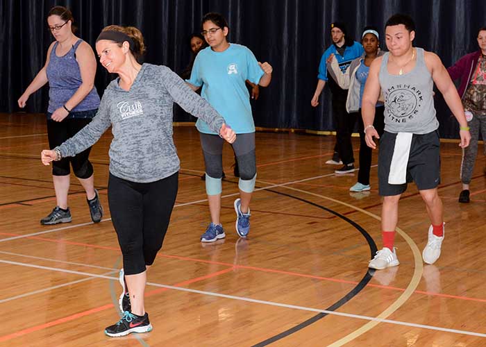 A female instructor teaches an aerobics-type class