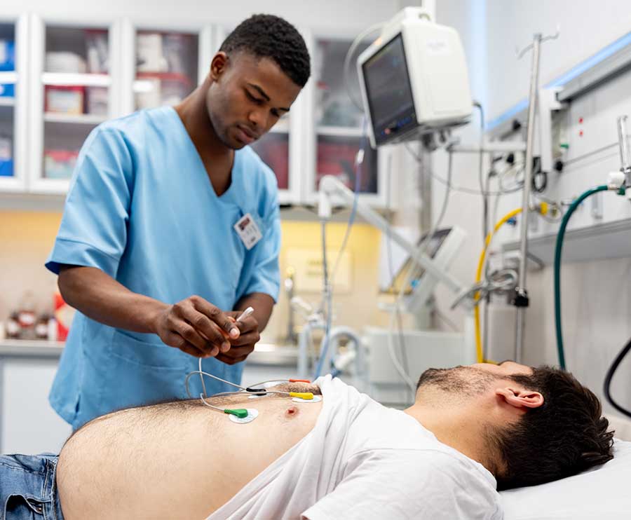 A technician performs an EKG on a patient.