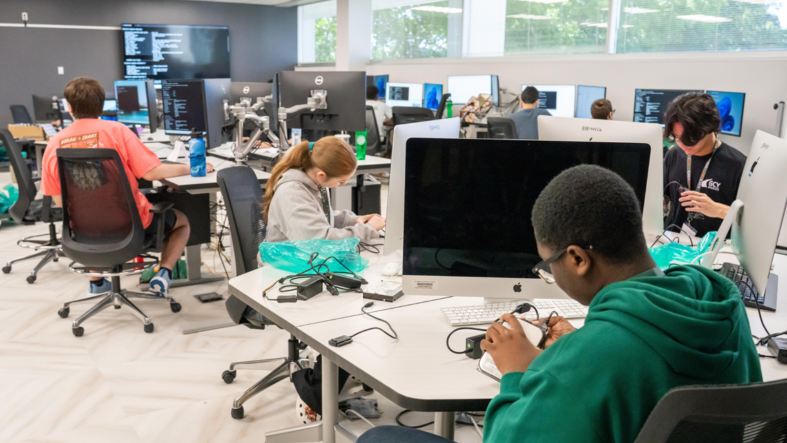 Campers inspecting hard disks in classroom