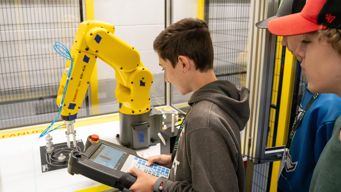 Camper controlling robot as other campers watch