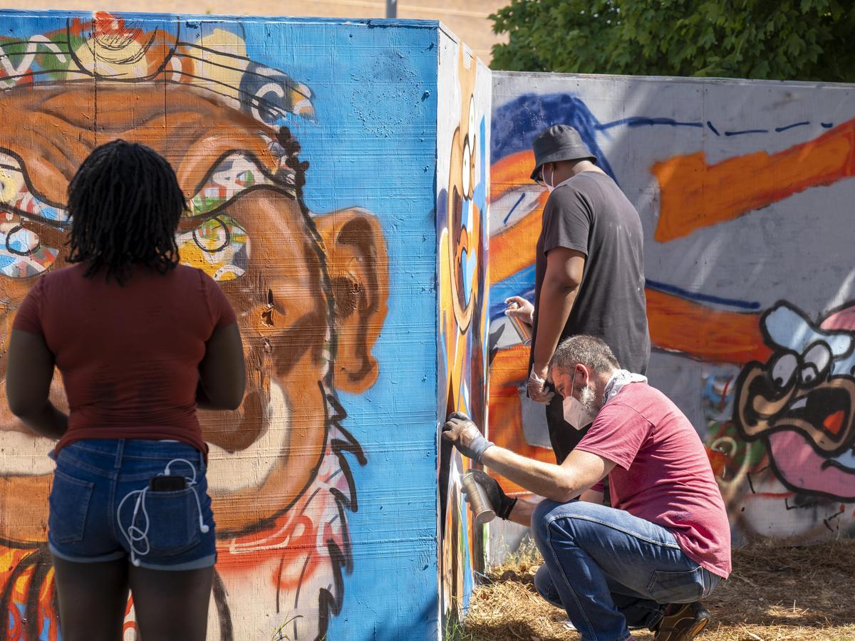 Students paint murals at Mural Magic.