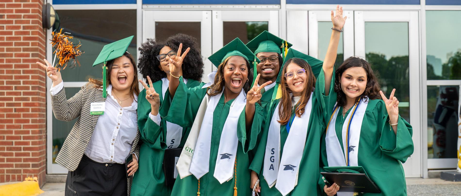 Six GTCC graduation students in their caps and gowns smiling for the camera