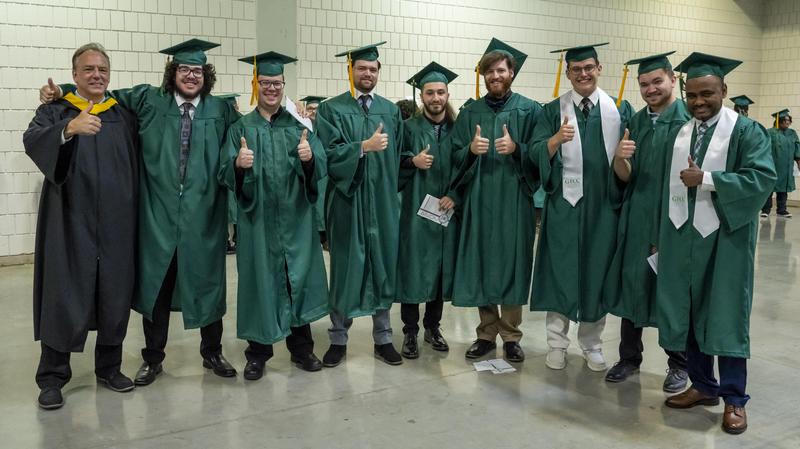 An instructor and several male students pose prior to the ceremony.