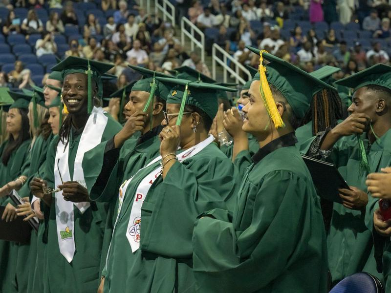 Students move their heads as their tassels swing during the graduation ceremony.