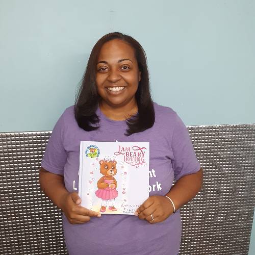 Instructor Airreia Pierce holds her book, "I am BEARY Loving."