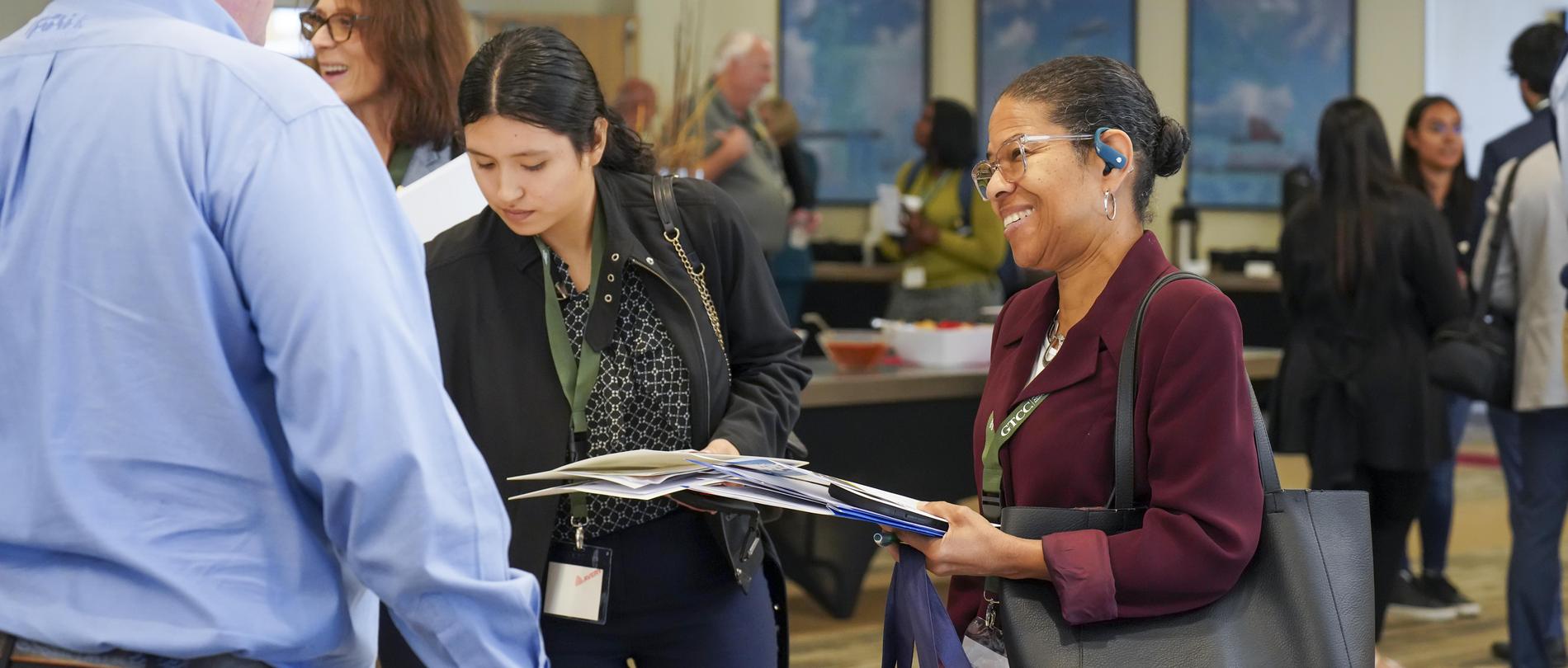 Two women talk to a company representative at a recent Supply Chain event.