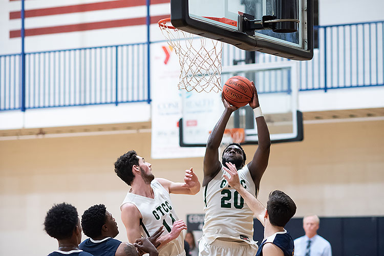 GTCC player shoots the ball at the basket with several defenders looking on.